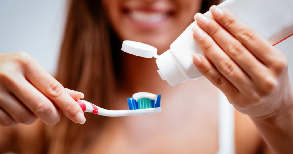 a woman using the best toothpaste to avoid root canal