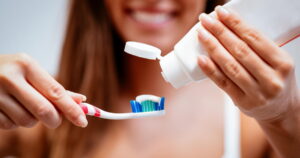 a woman using the best toothpaste to avoid root canal