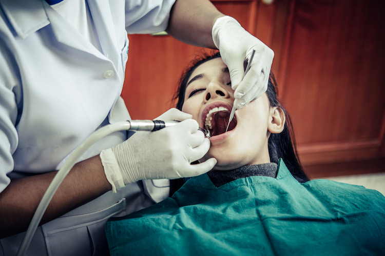 a dentist performing a root canal treatment for a patient.