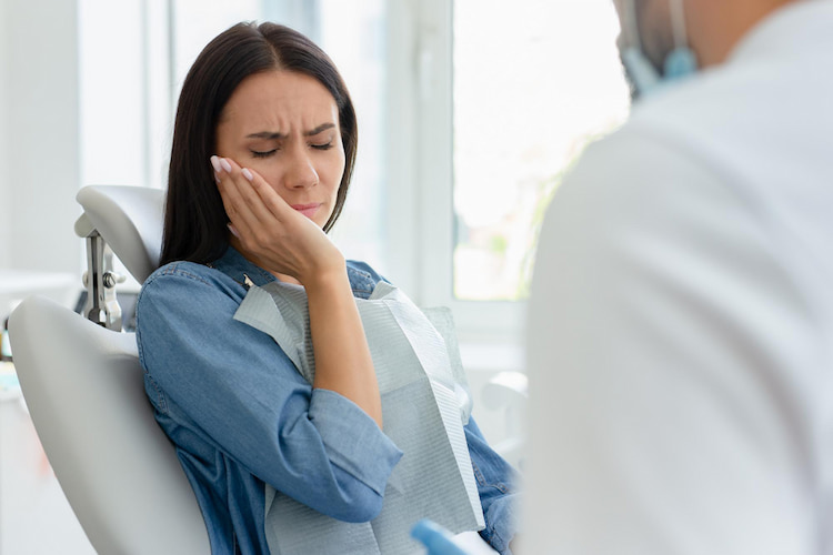 a woman is dealing with complications after wisdom tooth extraction and getting professional help from a dentist.