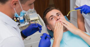 a patient sitting on a dental chair worried about his tooth extraction infection.