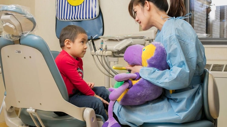 dentist trying to make Dental Visits Comfortable and Positive for a child