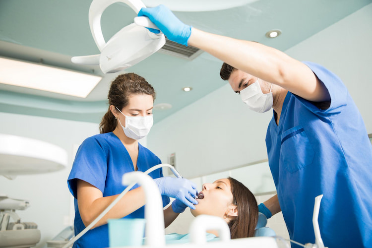 Dentist treating patient with dental tool with Dental Insurance for Emergency Care in Canada
