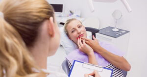 Female patient with toothache in clinic asking consultations for Dental Insurance for Emergency Care in Canada