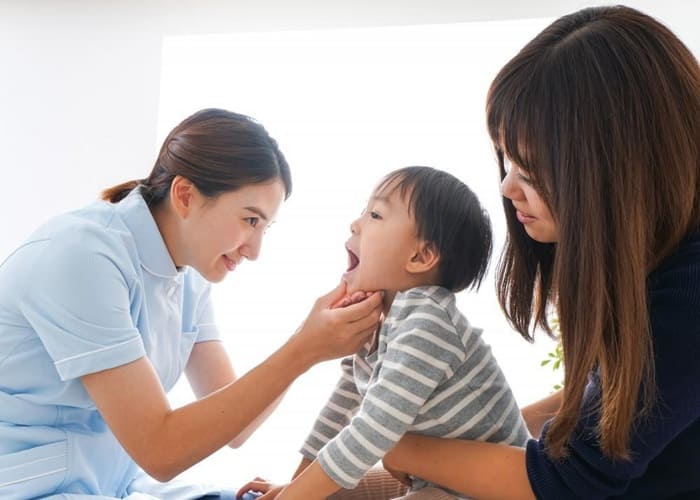 a child with her mom and a dentist