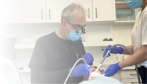 Dental professional and assistant examining a patient.